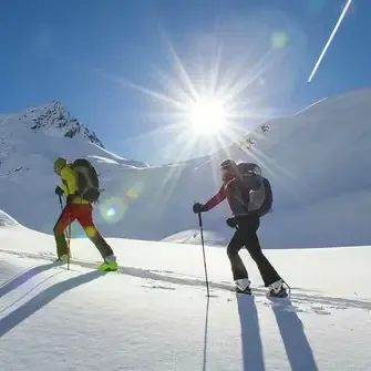 Zwei Personen machen eine Skitour auf einem Berg