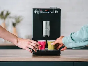 Zwei Tassen mit frisch gebrühtem Kaffee, die gleichzeitig aus dem Melitta Solo Kaffeevollautomaten befüllt werden