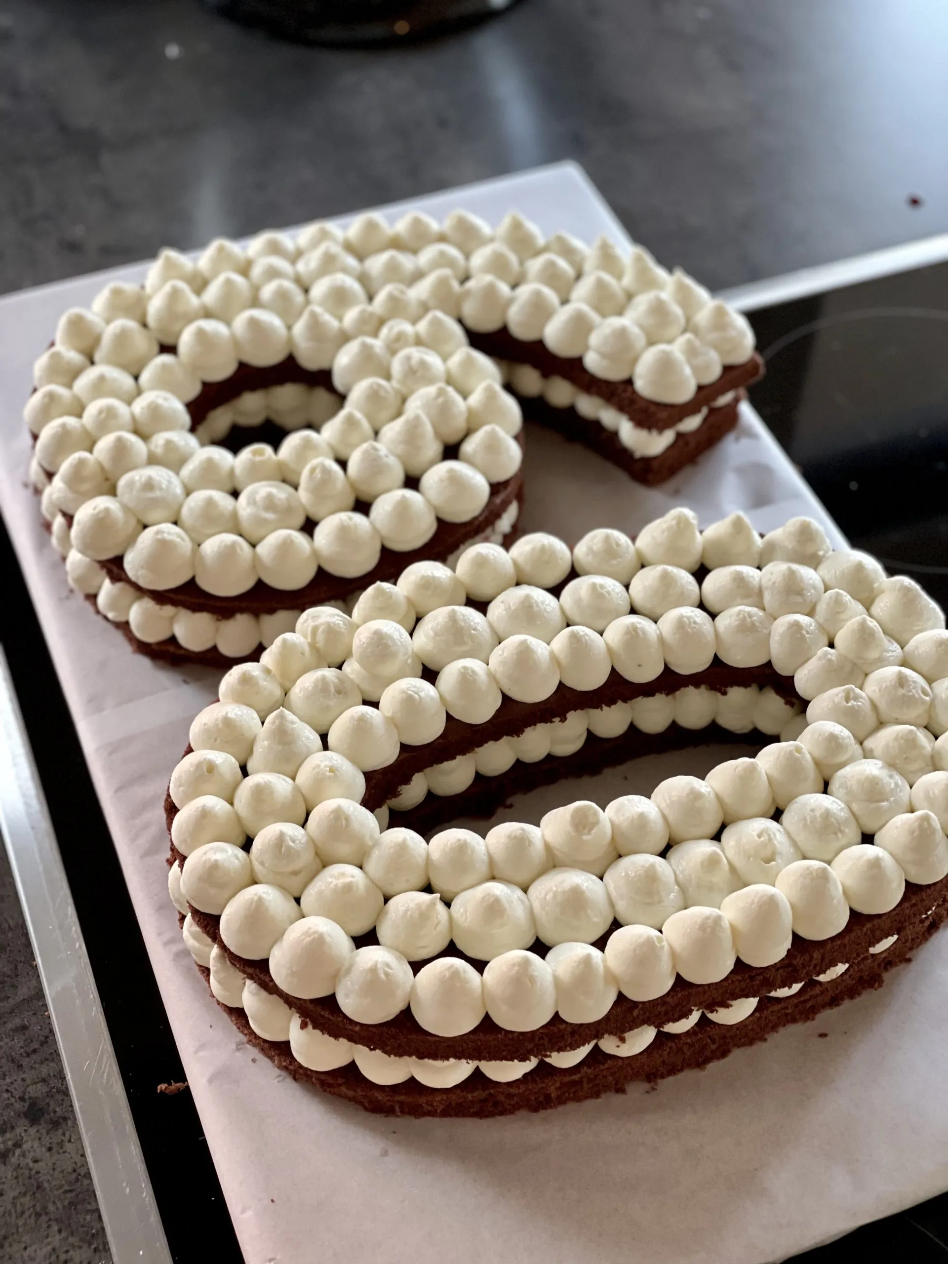 Zweite Schicht der Vanille-Mascarpone-Creme wird kunstvoll auf den Kuchen gespritzt