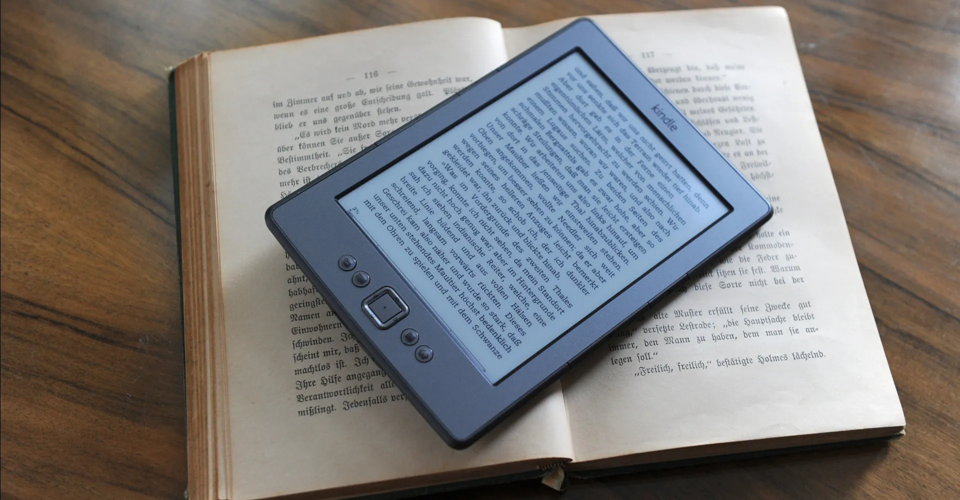 Ein Amazon Kindle eReader liegt auf einem aufgeschlagenem Buch.