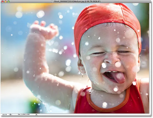 Ein Foto eines kleinen Jungen, der im Wasser spielt. Bildlizenz von iStockphoto von Photoshop Essentials.com.