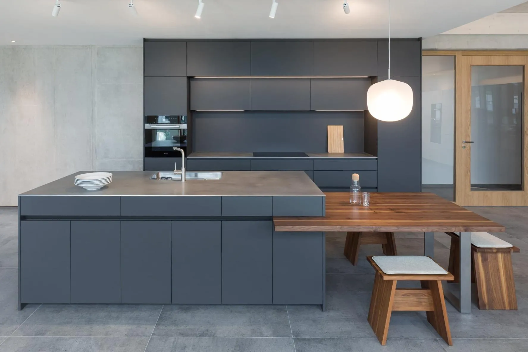 Graue Kücheninsel mit niedriger Sitzgelegenheit aus Holz