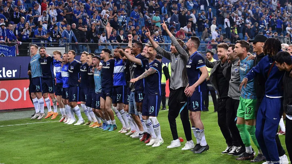 Hertha Berlin Spieler feiern mit den mitgereisten Fans den Klassenerhalt.