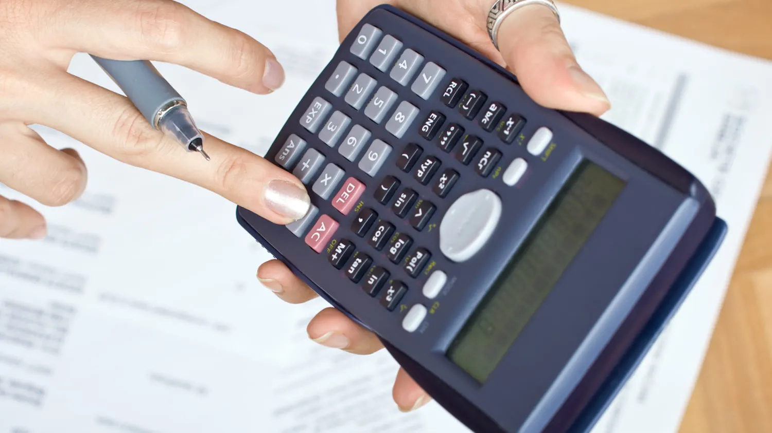 Betriebliche Altersvorsorge: Eine Frau berechnet die Kosten auf einem Taschenrechner.