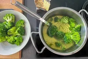 Brokkoliröschen mit einem Schaumlöffel aus dem Topf herausnehmen und abtropfen lassen