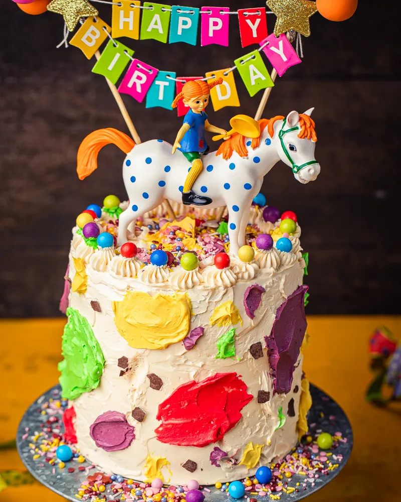 Bunte Pippi Langstrumpf Torte mit Streuseln und Figuren.