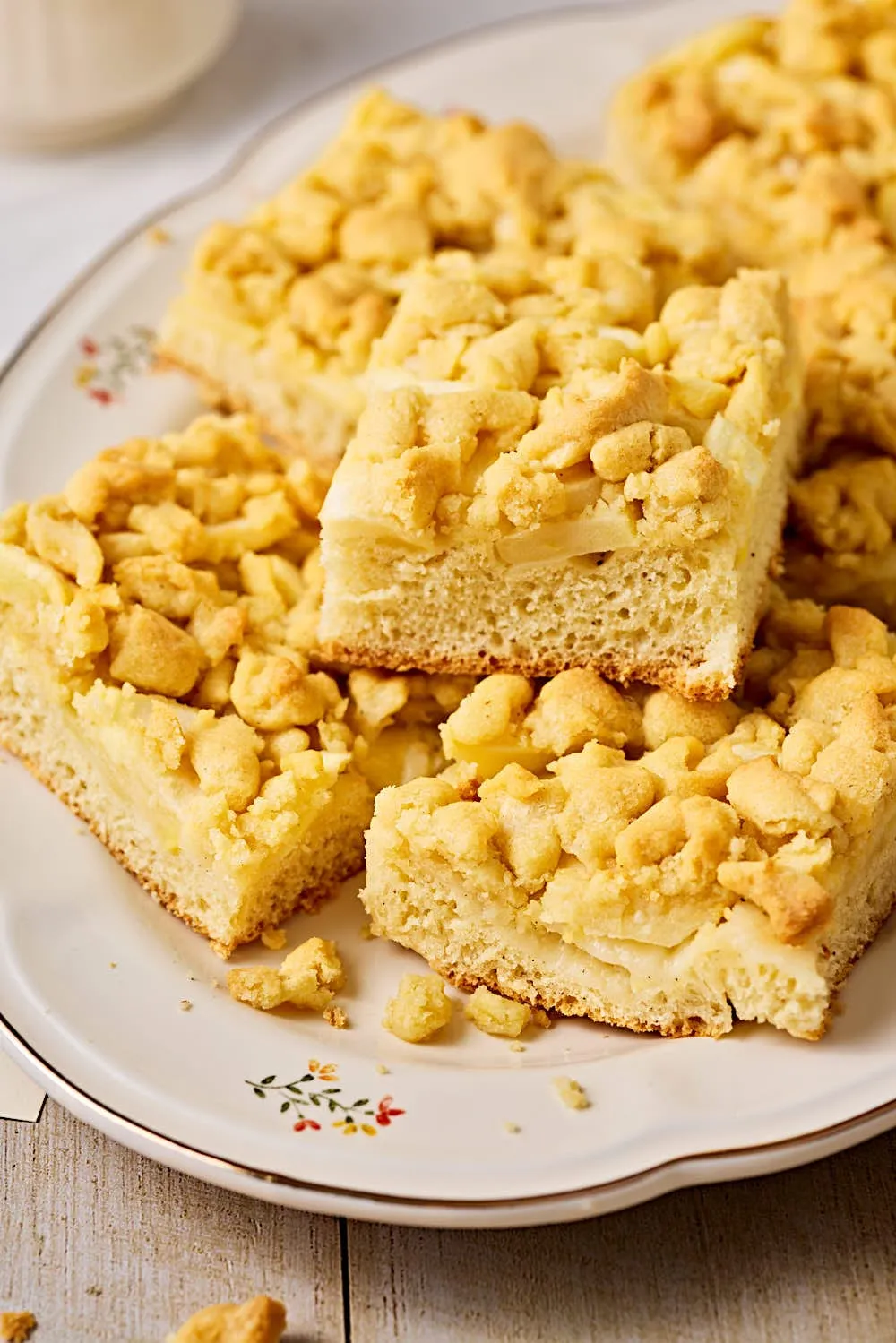 Der fertig gebackene Apfelkuchen mit Hefeteig und Streuseln auf einer Servierplatte.
