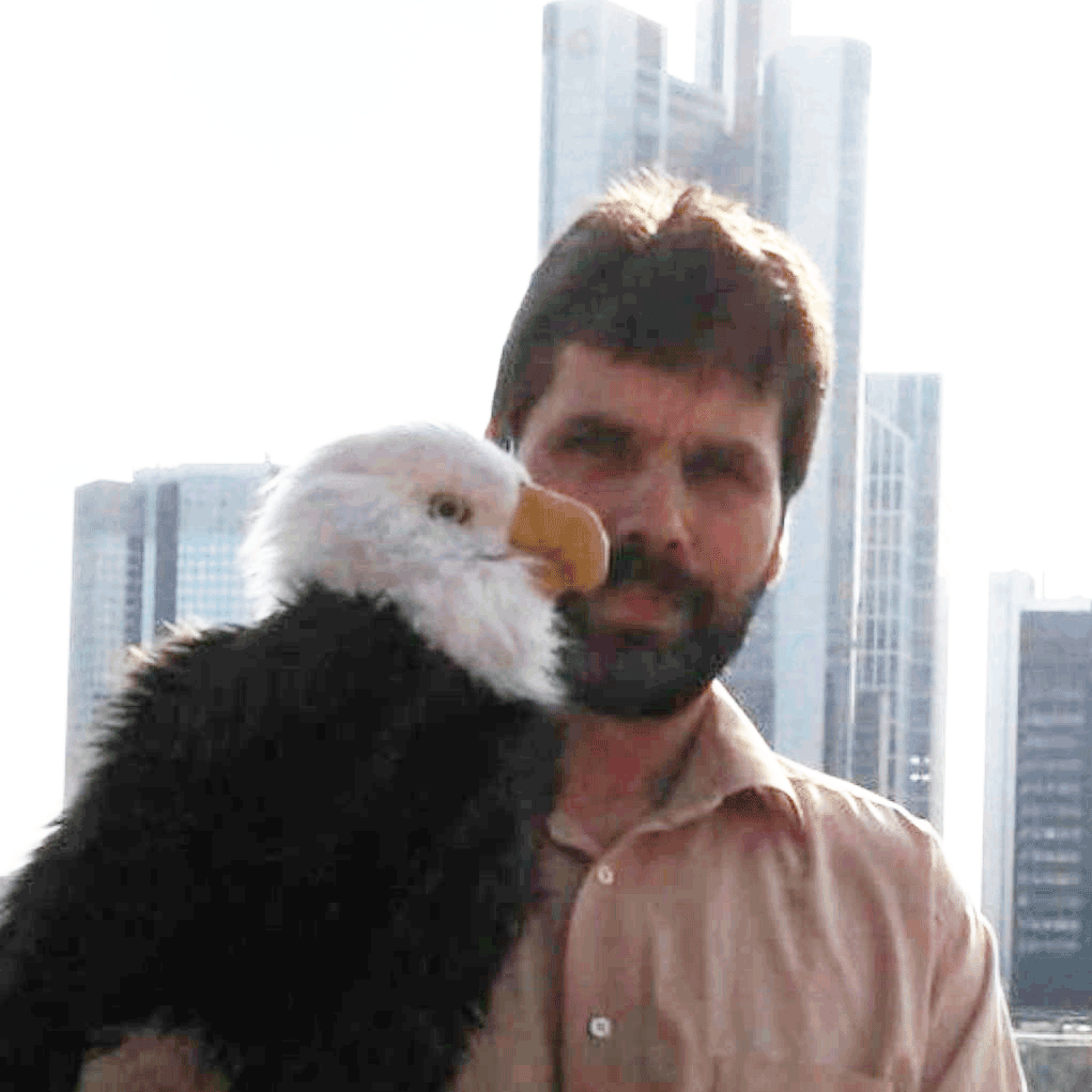 Dezente Darstellung des Mercedes-Benz Sterns auf einem Kühlergrill, im Hintergrund verschwommene Skyline Berlins