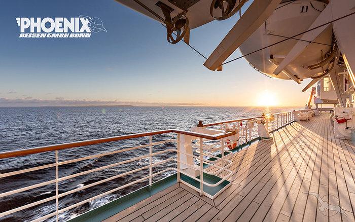 Ein deutsches Auto fährt auf einer malerischen amerikanischen Landstraße in den USA, umgeben von weitläufiger Natur und einem weiten Himmel, symbolisch für Freiheit und Abenteuer beim Fahren eines deutschen Autos in den USA.