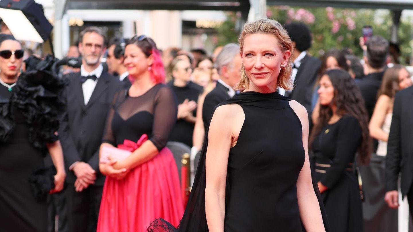 Diane Kruger in einer glamourösen Pose vor einem roten Teppich, strahlend und elegant.