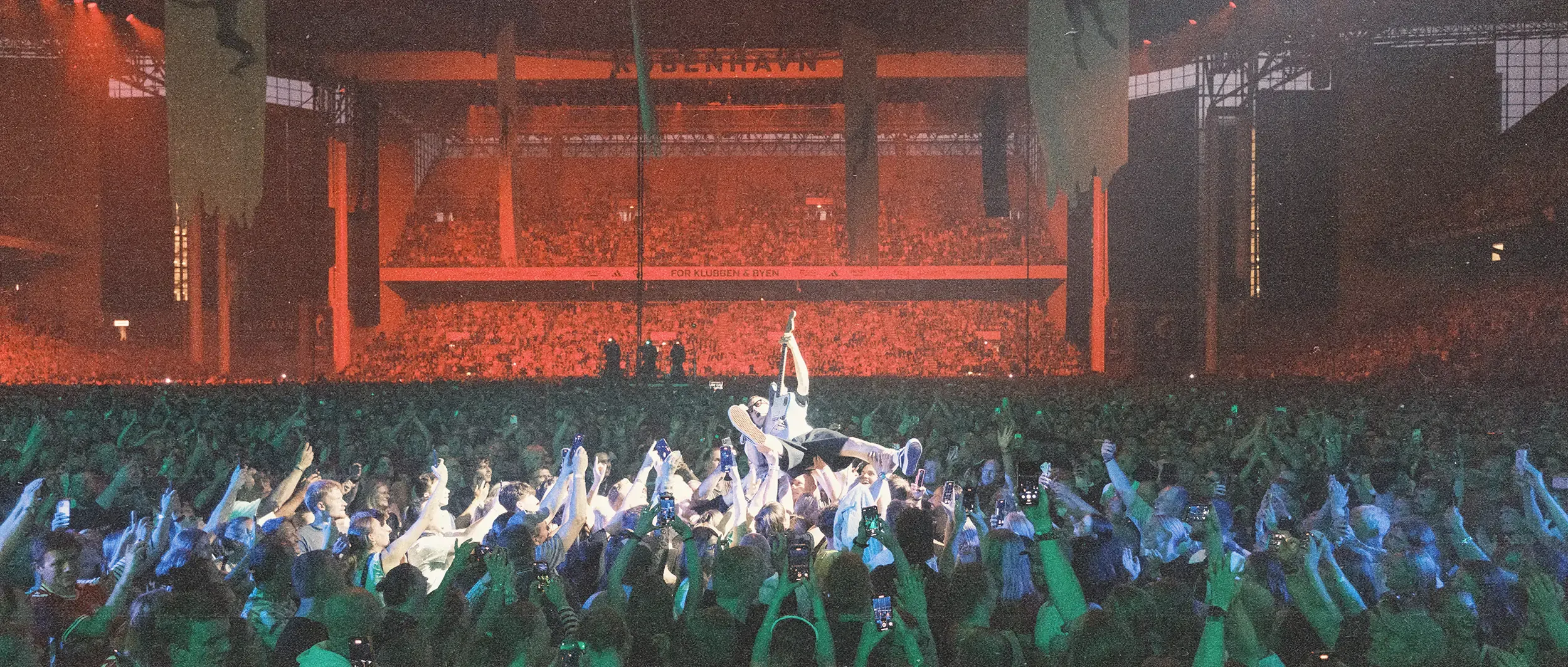 Drohnenaufnahme des Parken-Stadions während des Konzerts, die die schiere Größe der Veranstaltung und die beeindruckende Lichtshow zeigt