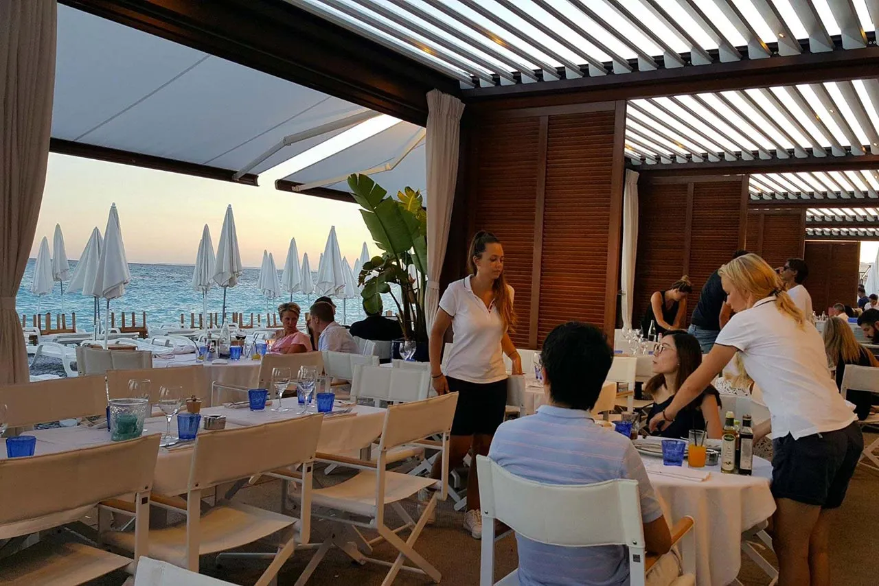 Ein modernes Restaurant mit Meerblick, in dem ein Paar zu Mittag isst