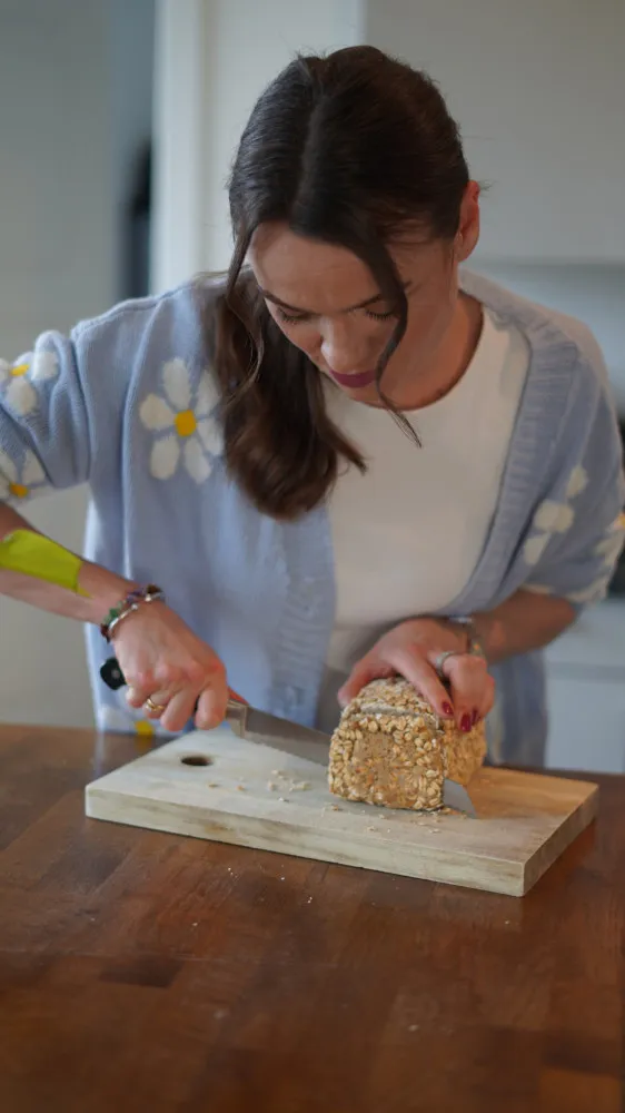 Frau schneidet eine Scheibe Brot ab
