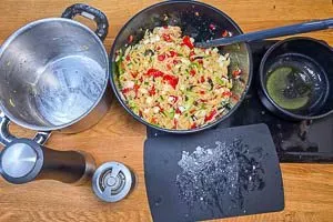 Gemüse und gekochte Kritharaki-Nudeln vermengen und Feta klein schneiden und dazu geben.