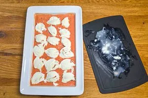 Hackbällchen mit der Tomatensoße übergießen und den Mozzarella darauf verteilen.