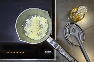 Knoblauch und Zwiebel in Olivenöl braten.