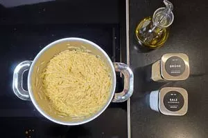 Kritharaki-Nudeln mit Salz und Gemüsebrühe kochen. Anschließend abgießen und mit Olivenöl vermischen.