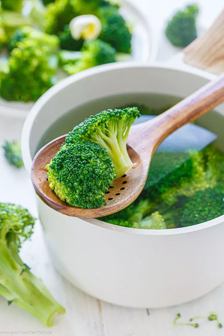 Leuchtend grüne Brokkoli-Röschen dampfen im Topf