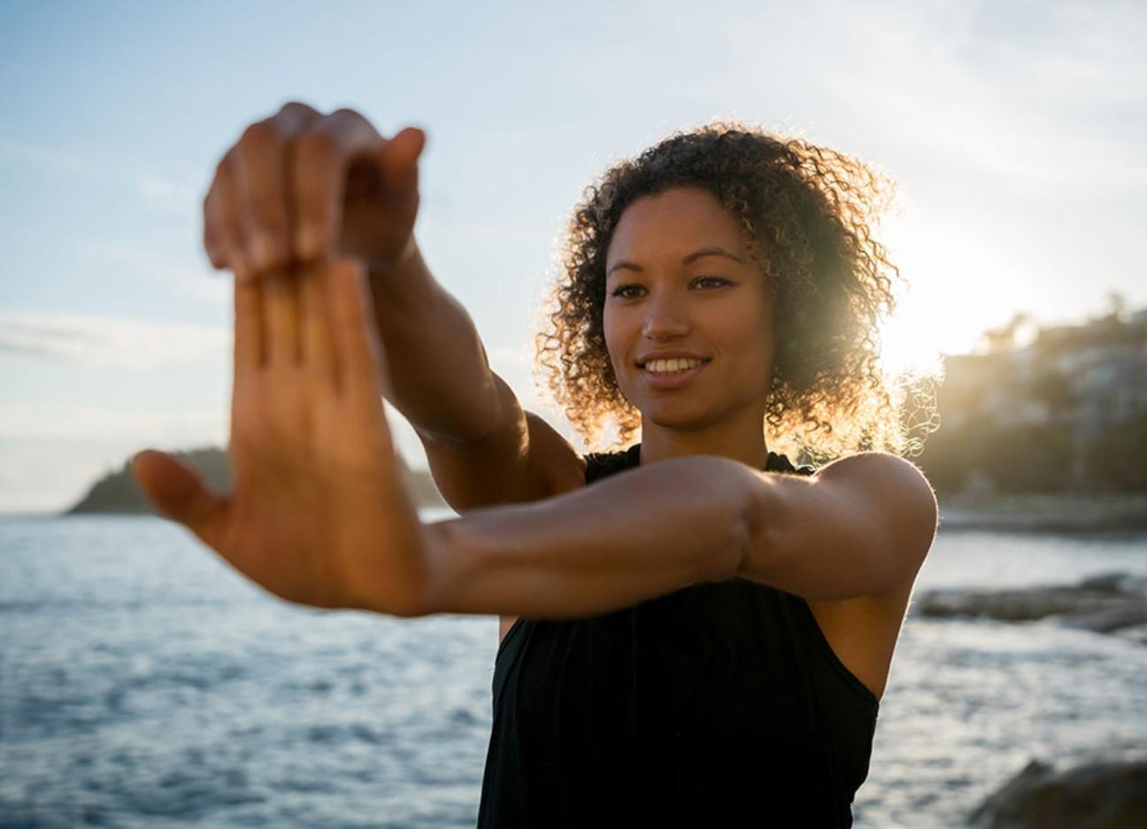 Eine glückliche junge Familie schiebt einen modernen Kinderwagen durch eine idyllische bayerische Landschaft, im Hintergrund die Alpen.