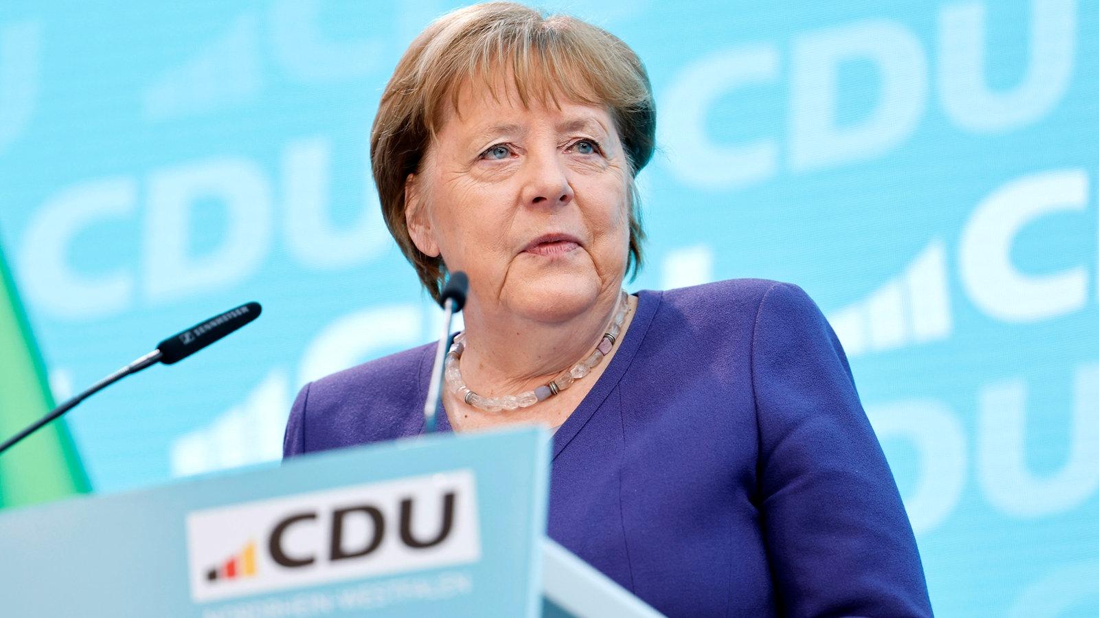 Angela Merkel bei einem Auftritt auf einer Bühne, nachdenklicher Ausdruck