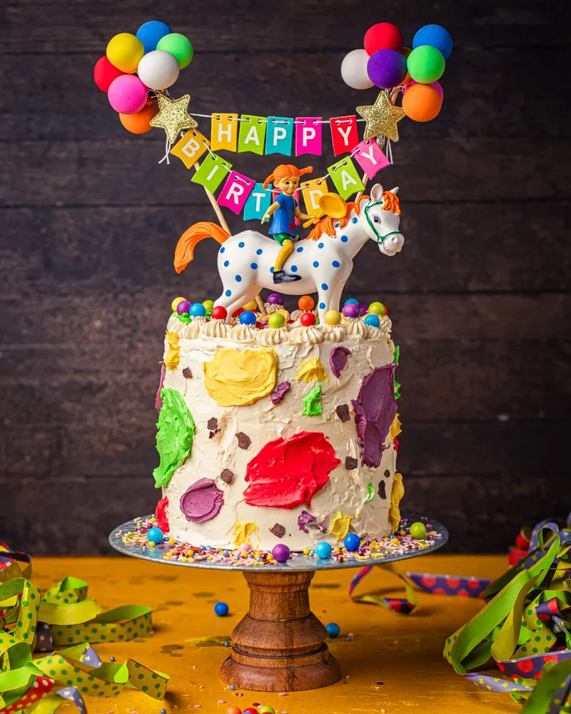 Pippi Langstrumpf Figur auf der Torte mit bunten Streuseln und Ballons