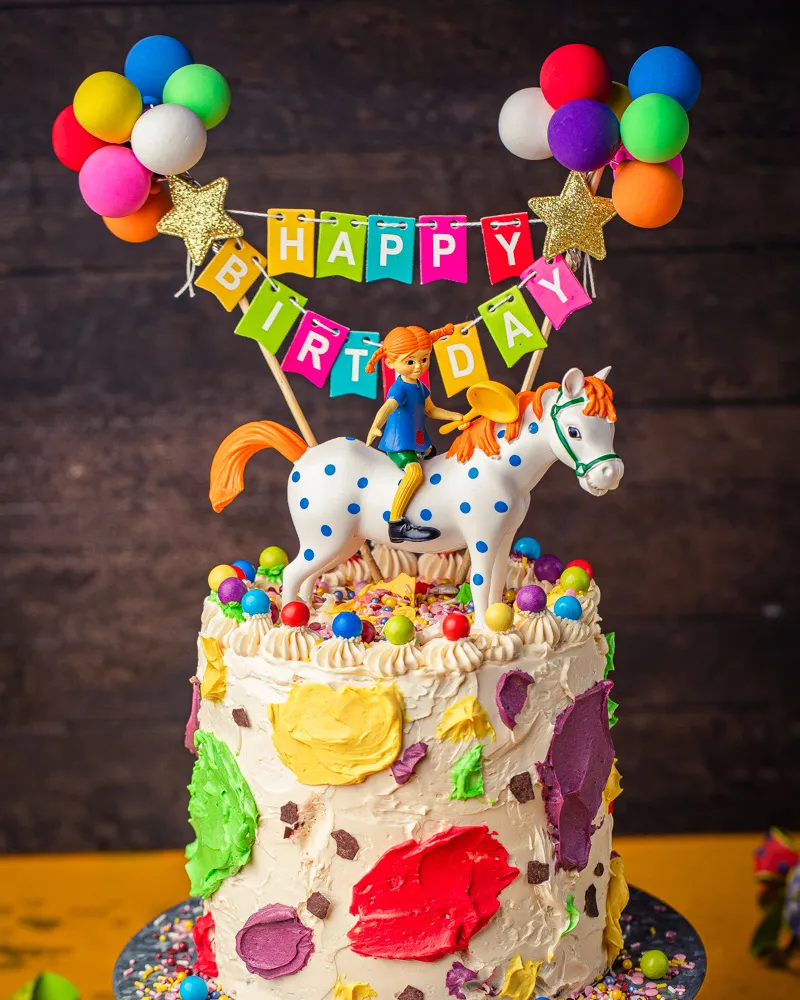 Pippi Langstrumpf und ihr Pferd Kleiner Onkel auf der bunten Torte