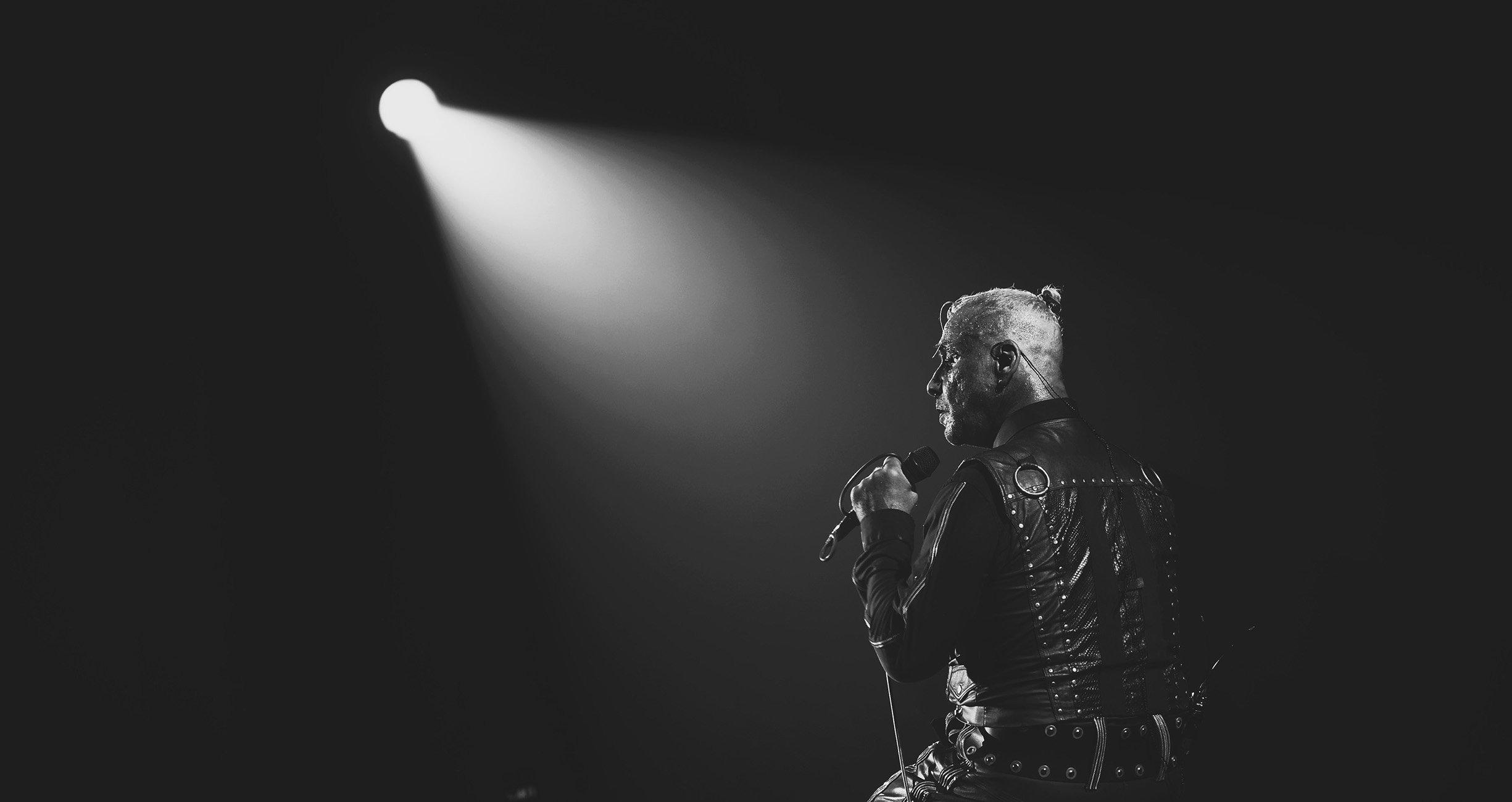 Till Lindemann in Aktion auf der Bühne mit Rammstein, während einer spektakulären Pyrotechnik-Show, die seine Bühnenpräsenz unterstreicht