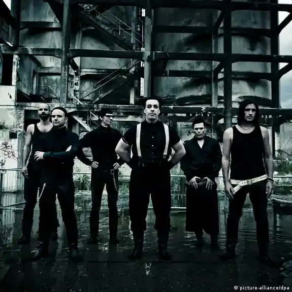 Till Lindemann mit Mikrofon vor dunklem Hintergrund, nachdenklicher Blick