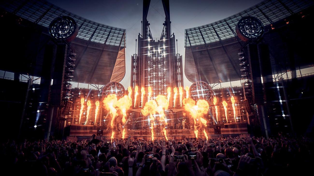Till Lindemann in Aktion auf der Rammstein-Bühne, mit intensiver Beleuchtung und Pyrotechnik