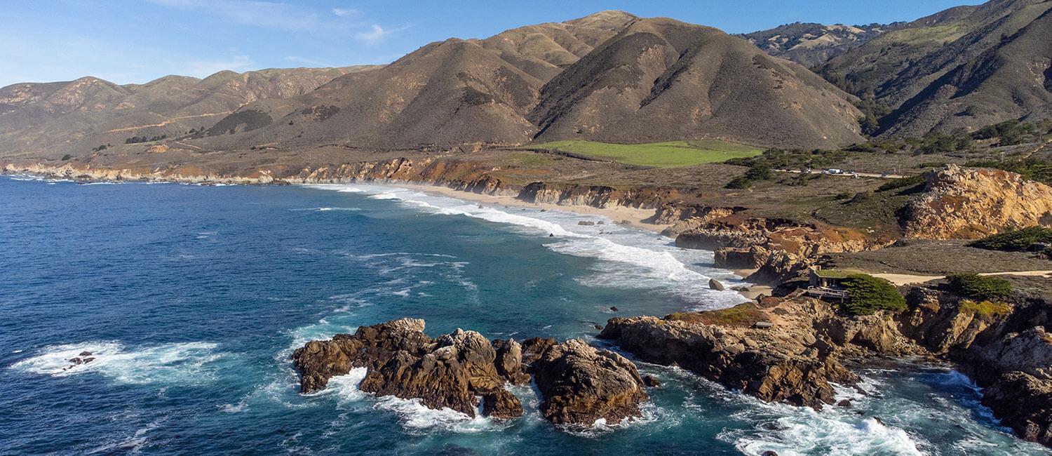 Eine malerische Roadtrip-Szene in den USA mit einem deutschen Paar, das einen Mietwagen fährt und die Freiheit der offenen Straße genießt.