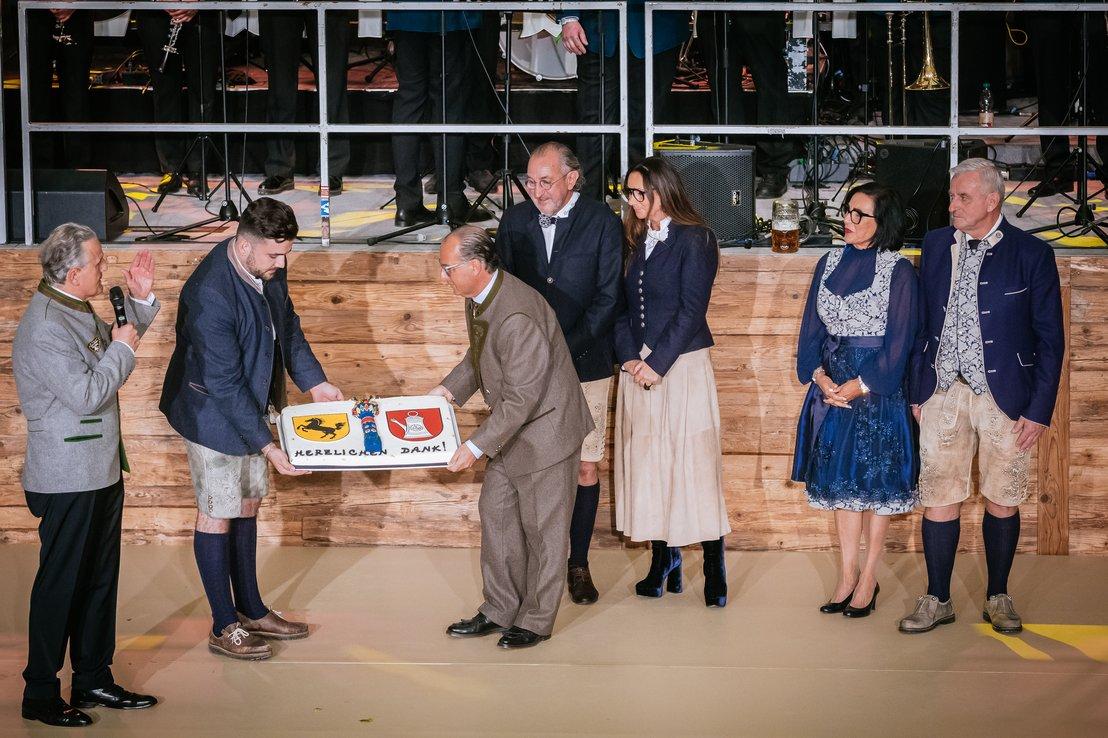 Blick auf ein traditionelles deutsches Bierfass auf einem Volksfest, mit fröhlichen Menschen im Hintergrund