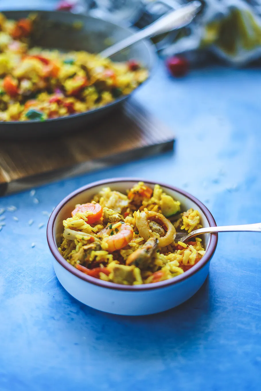 Spanische Paella Mixta, garniert mit Zitrone und Petersilie